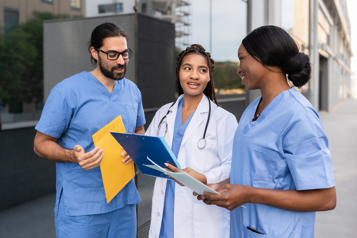 Nurses Standing and Talking Outside of a Medical Facility Nurses standing and talking outside of a medical facility.
